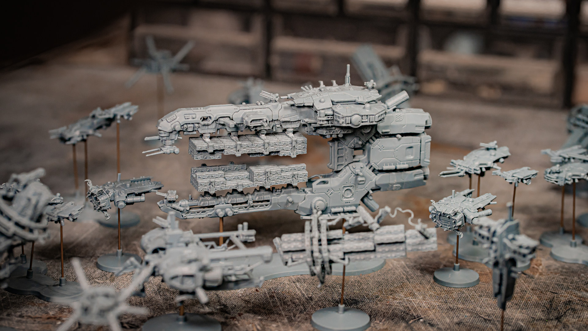 A large cargo spaceship surrounded by a fleet of smaller miniatures