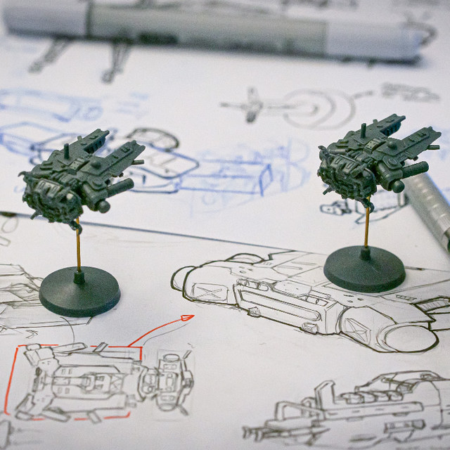Spaceship miniatures on their design sketches