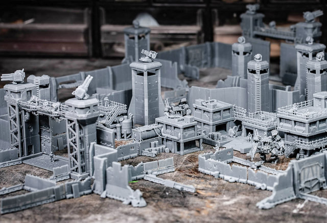 Unpainted sci-fi miniature fortifications, industrial buildings and mechs